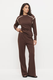 Woman wearing embroidered fleeced-back jersey sweatpants in a regular straight leg fit with contrast side seam embroidery and a topstitched elasticated waistband.