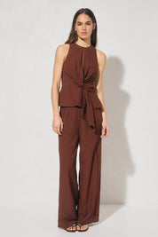 Sleeveless textured woven top with crew neckline, ladder trim detail, twisted waist sash, and side seam splits