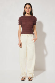 Skimming fit knitted tee shirt with round neckline, short sleeves, horizontal shirring detail, and narrow ribbed trims