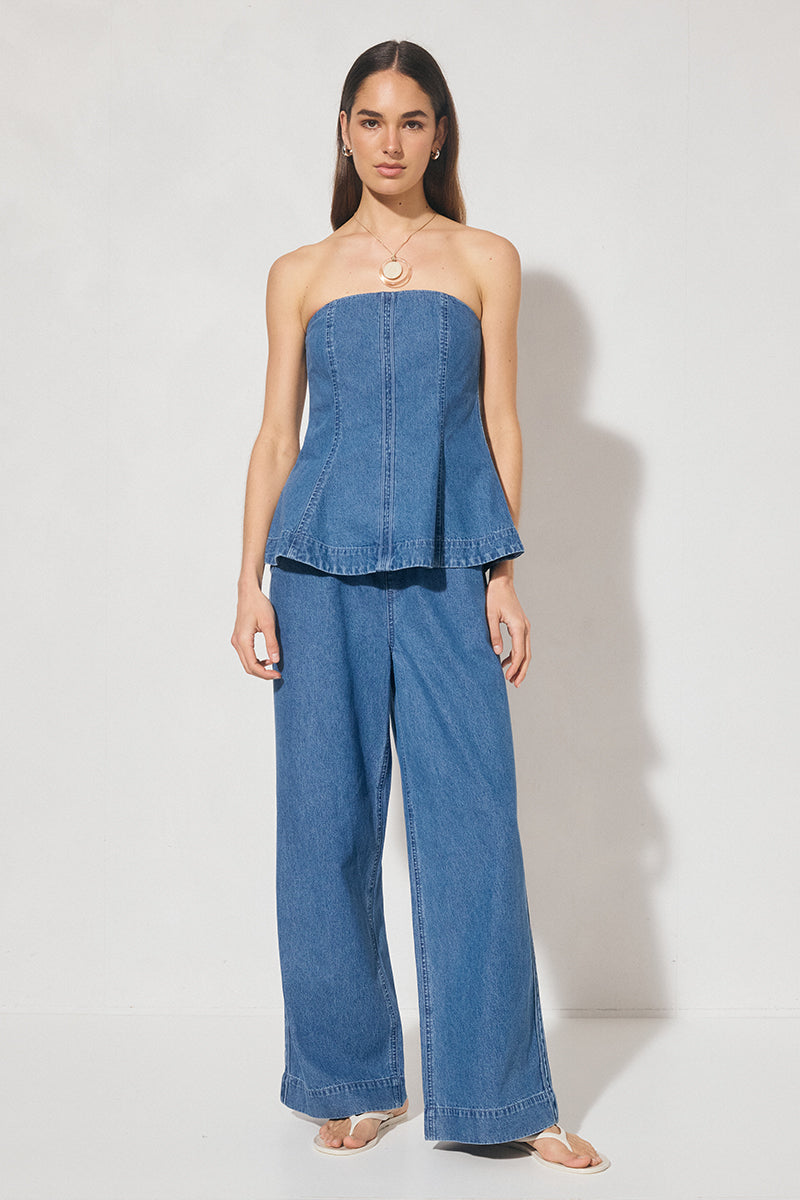 Wide-leg denim jeans with elastic waistband, cornelli piping, slant front pockets, back welt pockets, and heavy topstitching