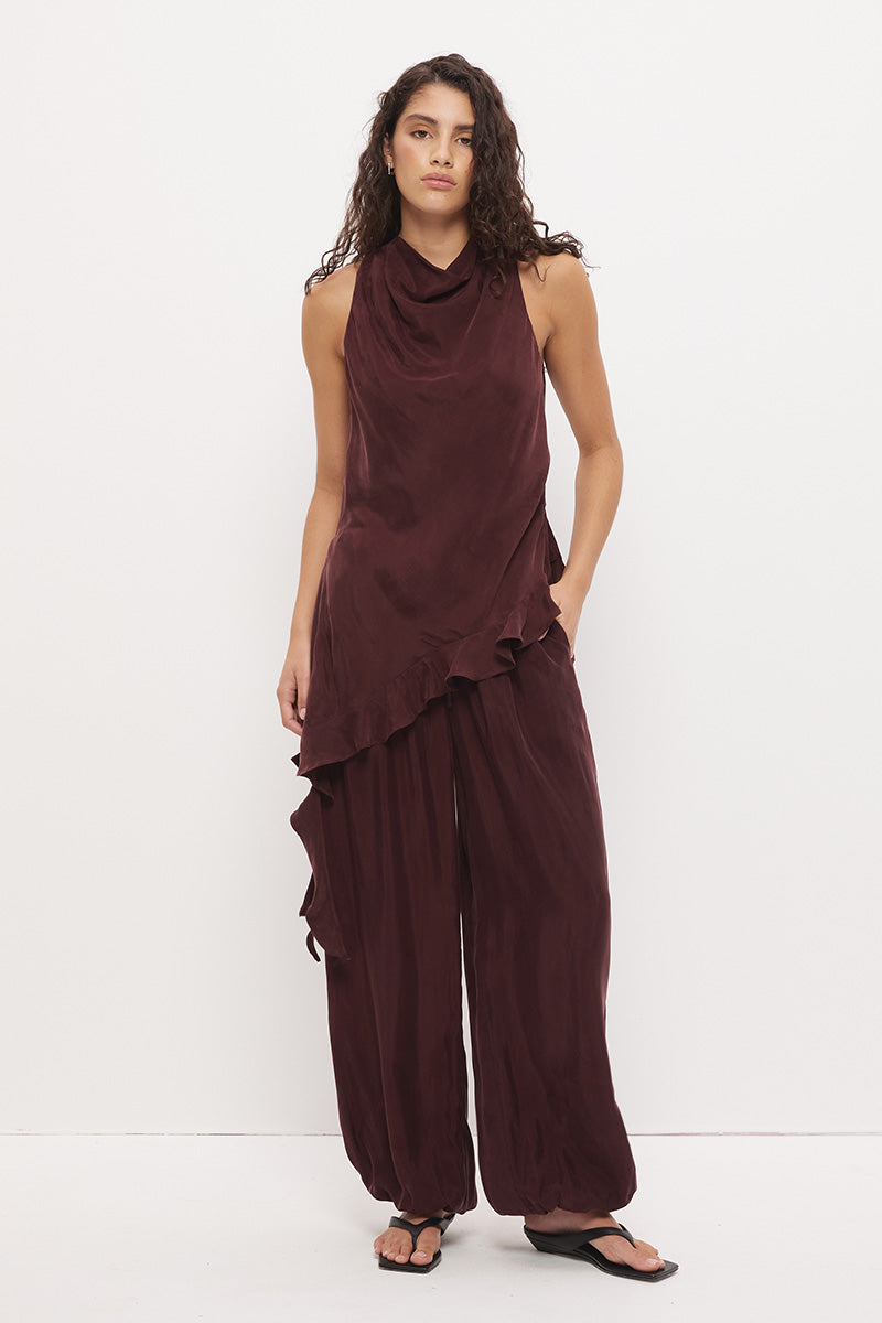 Sleeveless longline top in brushed cupro satin with narrow cowl neckline and asymmetric spiral flounce hem