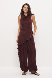 Sleeveless longline top in brushed cupro satin with narrow cowl neckline and asymmetric spiral flounce hem
