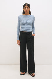 Woman wearing a textured lace long sleeve top with a boat neckline, semi-sheer sleeves, and centre front chest ruching in a skimming fit.