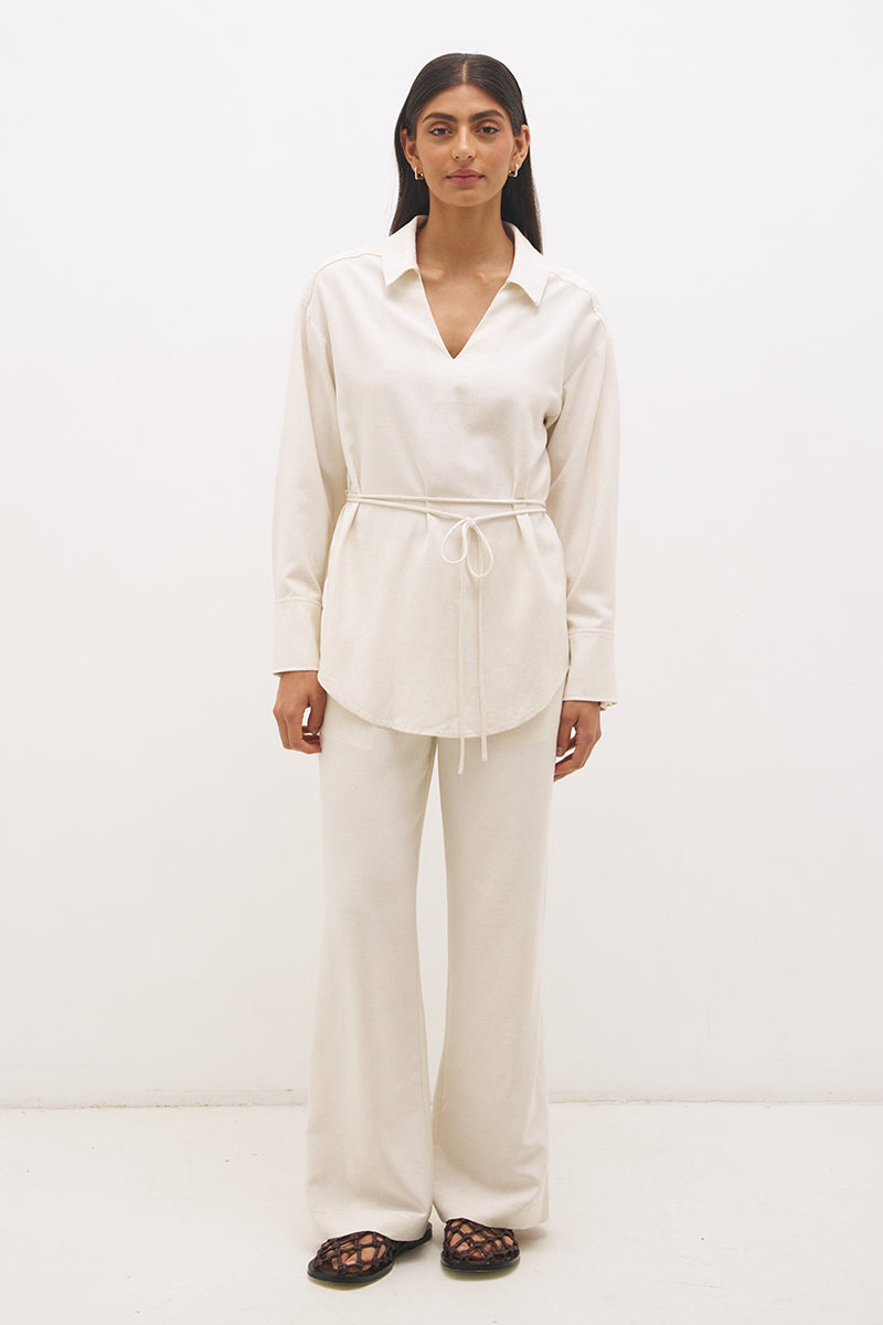 Woman wearing a satin-backed linen blend longline tunic with V neckline, curved hem, relaxed fit, and removable waist tie