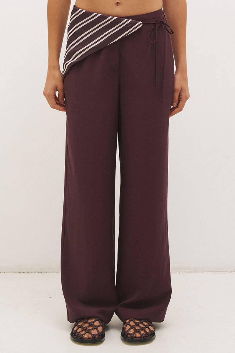Woman wearing satin-backed linen blend wide leg pants with high-rise fit, scarf waist tie, elasticated back waistband, and relaxed tailored silhouette