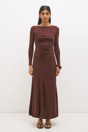 Woman wearing a textured cupro jersey long sleeve midi dress with boat neckline, cascading ruching, fit-and-flare silhouette, and draped A-line hem