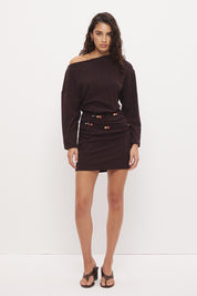 Oversized jersey mini dress with boat neckline, beaded asymmetrical waist straps, cinched silhouette, and fitted mini skirt