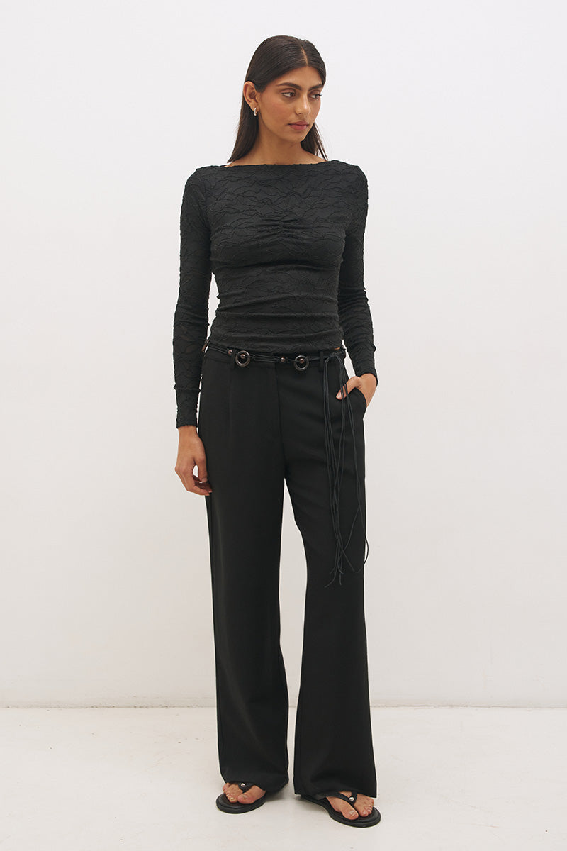 Woman wearing a textured lace long sleeve top with a boat neckline, semi-sheer sleeves, and centre front chest ruching in a skimming fit.