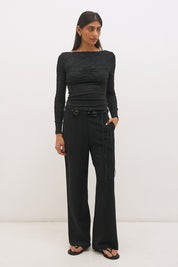 Woman wearing a textured lace long sleeve top with a boat neckline, semi-sheer sleeves, and centre front chest ruching in a skimming fit.