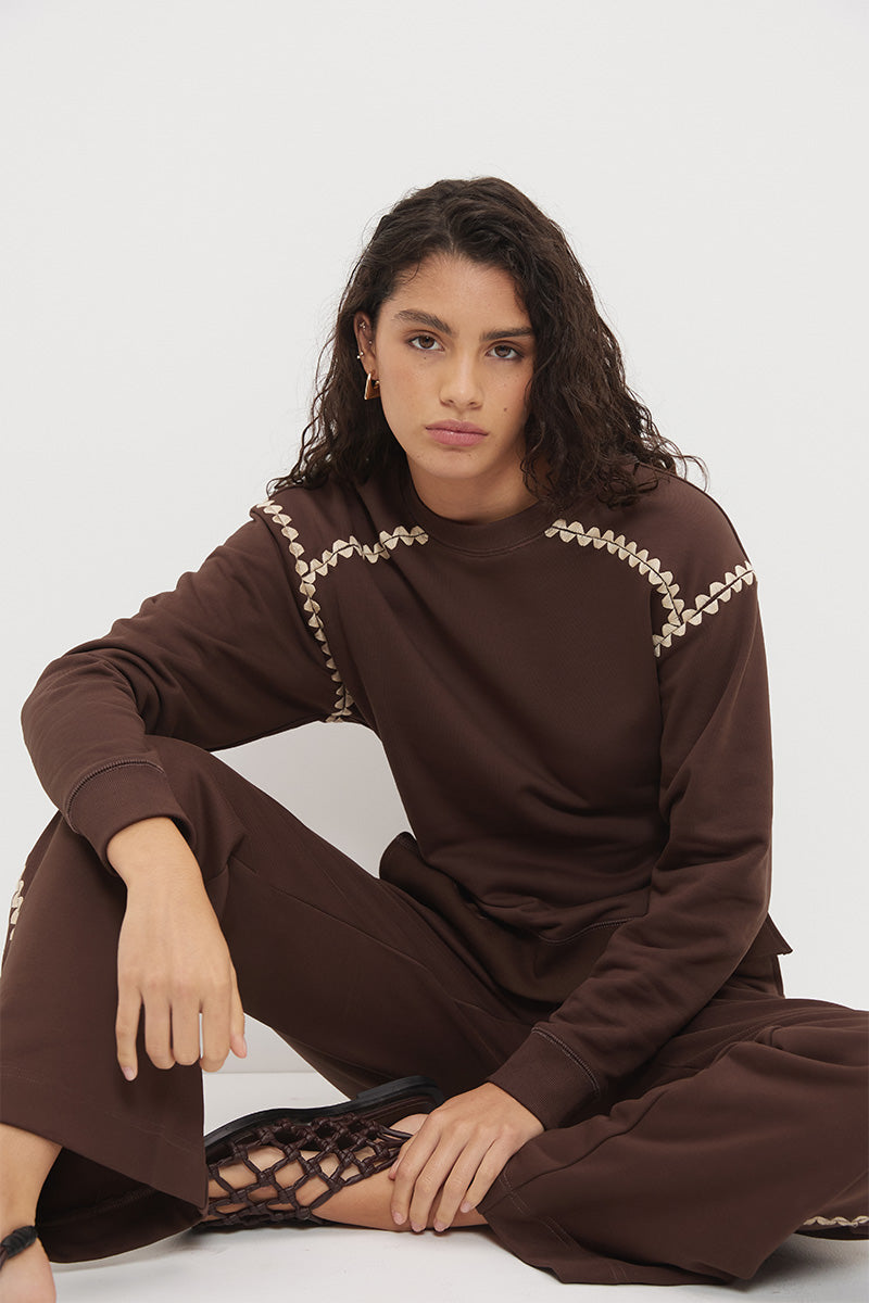 Embroidered fleeced-back sweatshirt with crew neckline, dropped shoulders, waist tucks, and ribbed hem band