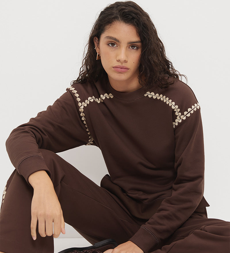 Embroidered fleeced-back sweatshirt with crew neckline, dropped shoulders, waist tucks, and ribbed hem band