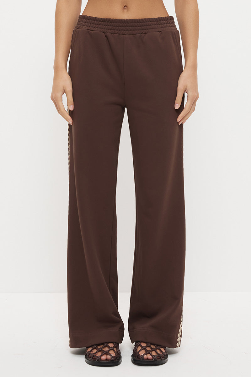 Woman wearing embroidered fleeced-back jersey sweatpants in a regular straight leg fit with contrast side seam embroidery and a topstitched elasticated waistband.