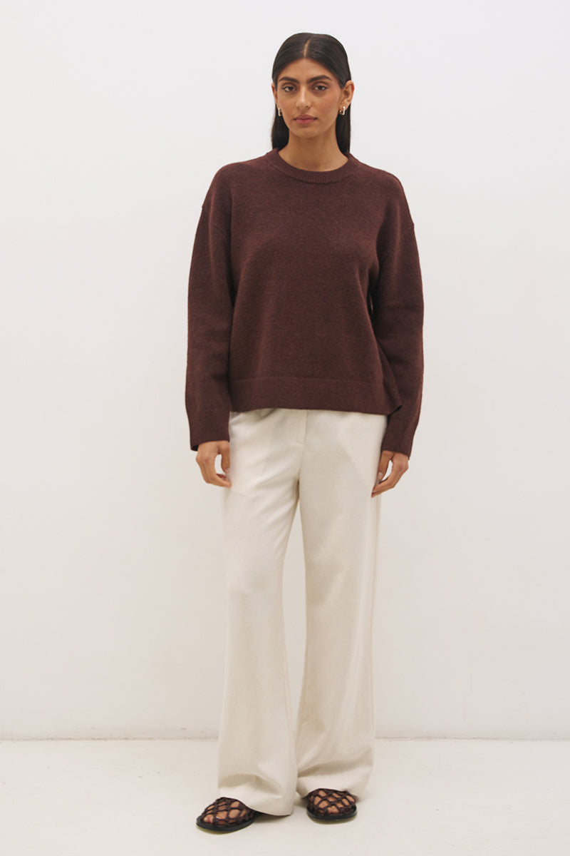 Woman wearing oversized scarf knit jumper with removable tassel scarf, crew neckline, ribbed trims, and relaxed silhouette