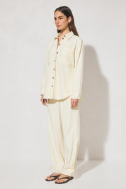 Long-sleeved oversized denim shirt with dropped shoulders, collar & stand, back box-pleat, back waist tie, chest patch pockets, side hem splits, and contrast topstitching