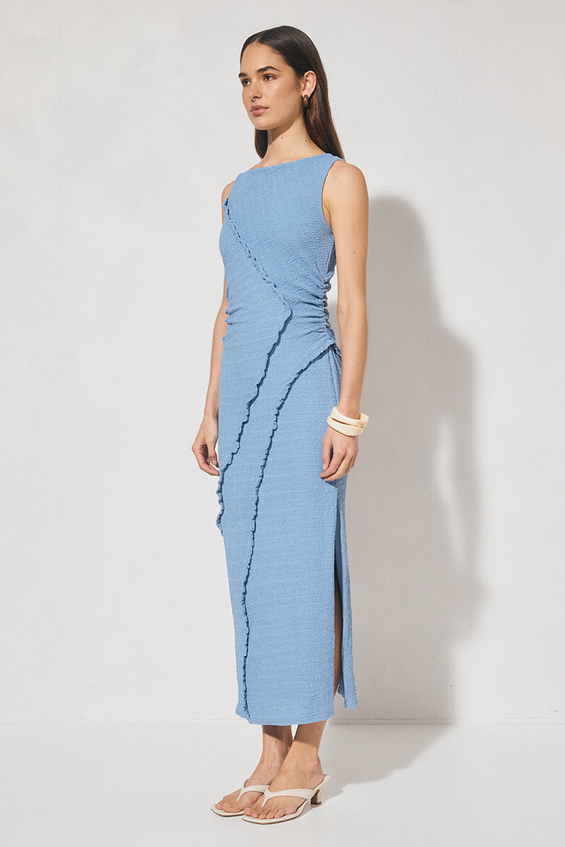 Sleeveless midi dress in textured jersey with skimming column silhouette, boat neckline, waist gathering, contrast frill panel detailing, and side seam split