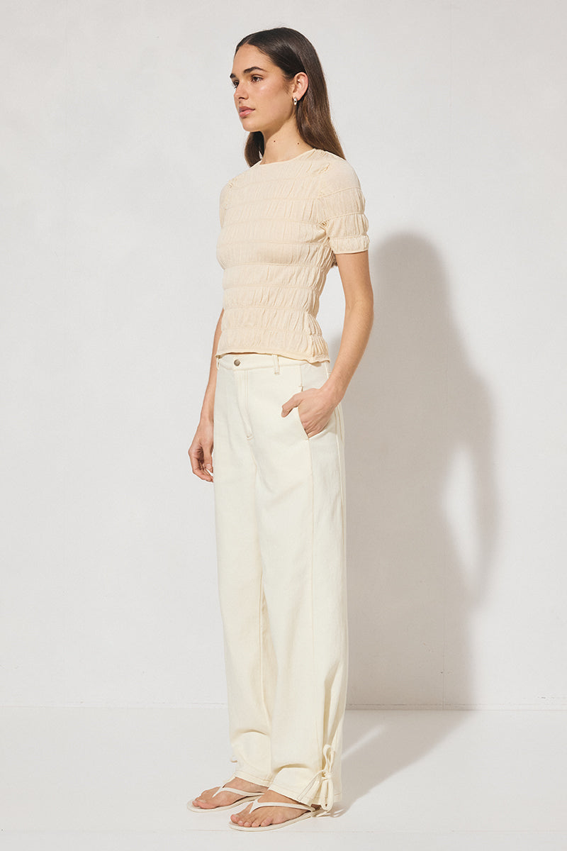 Skimming fit knitted tee shirt with round neckline, short sleeves, horizontal shirring detail, and narrow ribbed trims