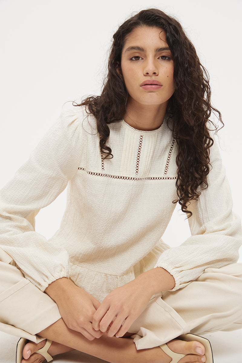 Long sleeve seersucker blouse with scalloped round neckline, balloon sleeves and lace-trimmed peplum hem