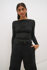 Woman wearing a textured lace long sleeve top with a boat neckline, semi-sheer sleeves, and centre front chest ruching in a skimming fit.