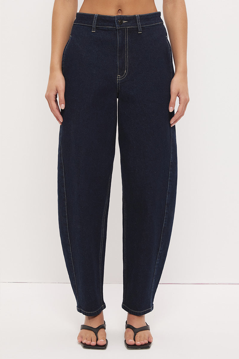 High-rise stretch denim barrel leg jeans with curved silhouette, contrast topstitching, and panelled construction