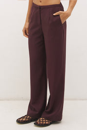 Woman wearing satin-backed linen blend wide leg pants with high-rise fit, scarf waist tie, elasticated back waistband, and relaxed tailored silhouette