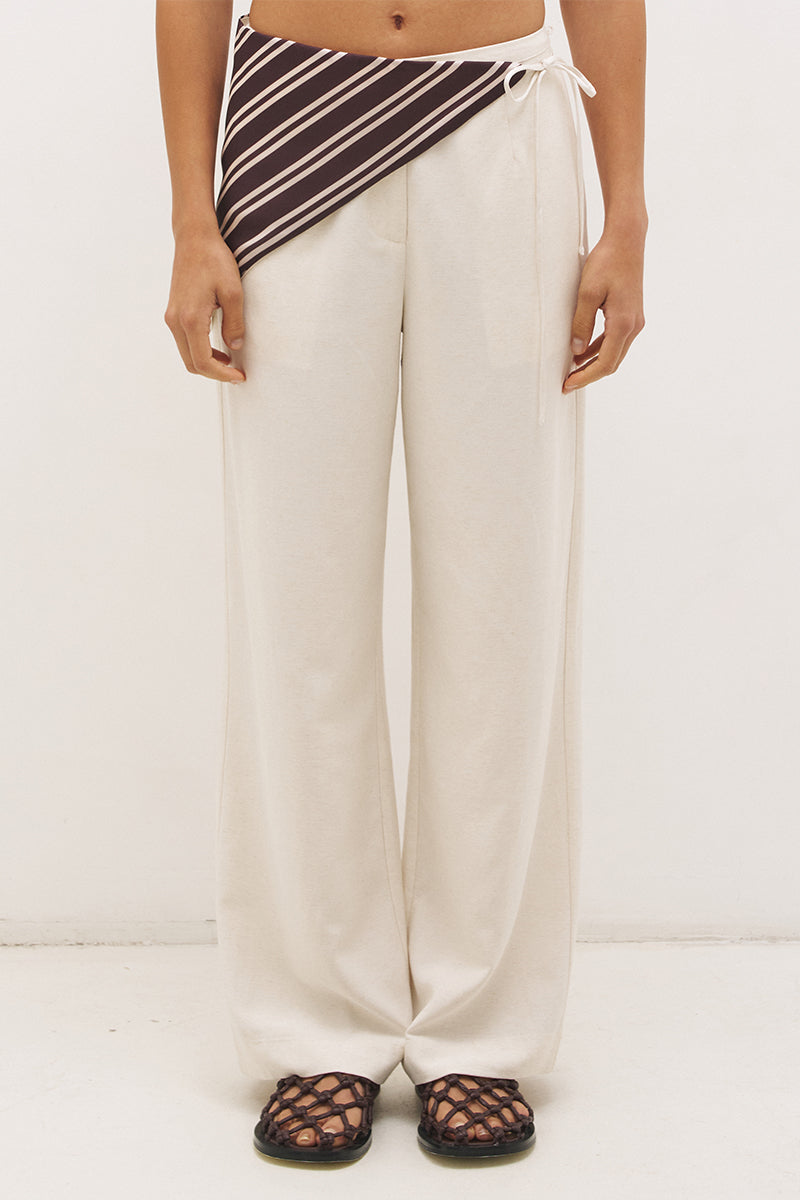 Woman wearing satin-backed linen blend wide leg pants with high-rise fit, scarf waist tie, elasticated back waistband, and relaxed tailored silhouette