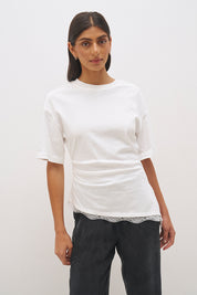 Cotton jersey tee with cinched waist, angled tuck detail, side splits and lace trim hem