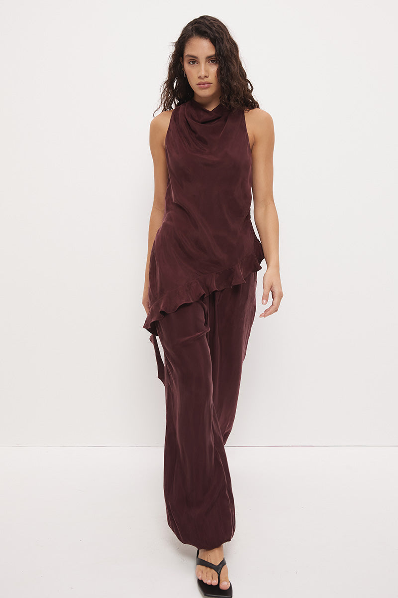 Sleeveless longline top in brushed cupro satin with narrow cowl neckline and asymmetric spiral flounce hem