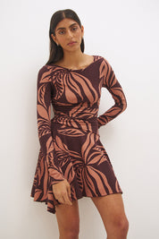 Printed handkerchief hem mini dress with boat neckline, ruched long sleeves, gathered bodice, and hi-lo draped skirt in stretch modal jersey