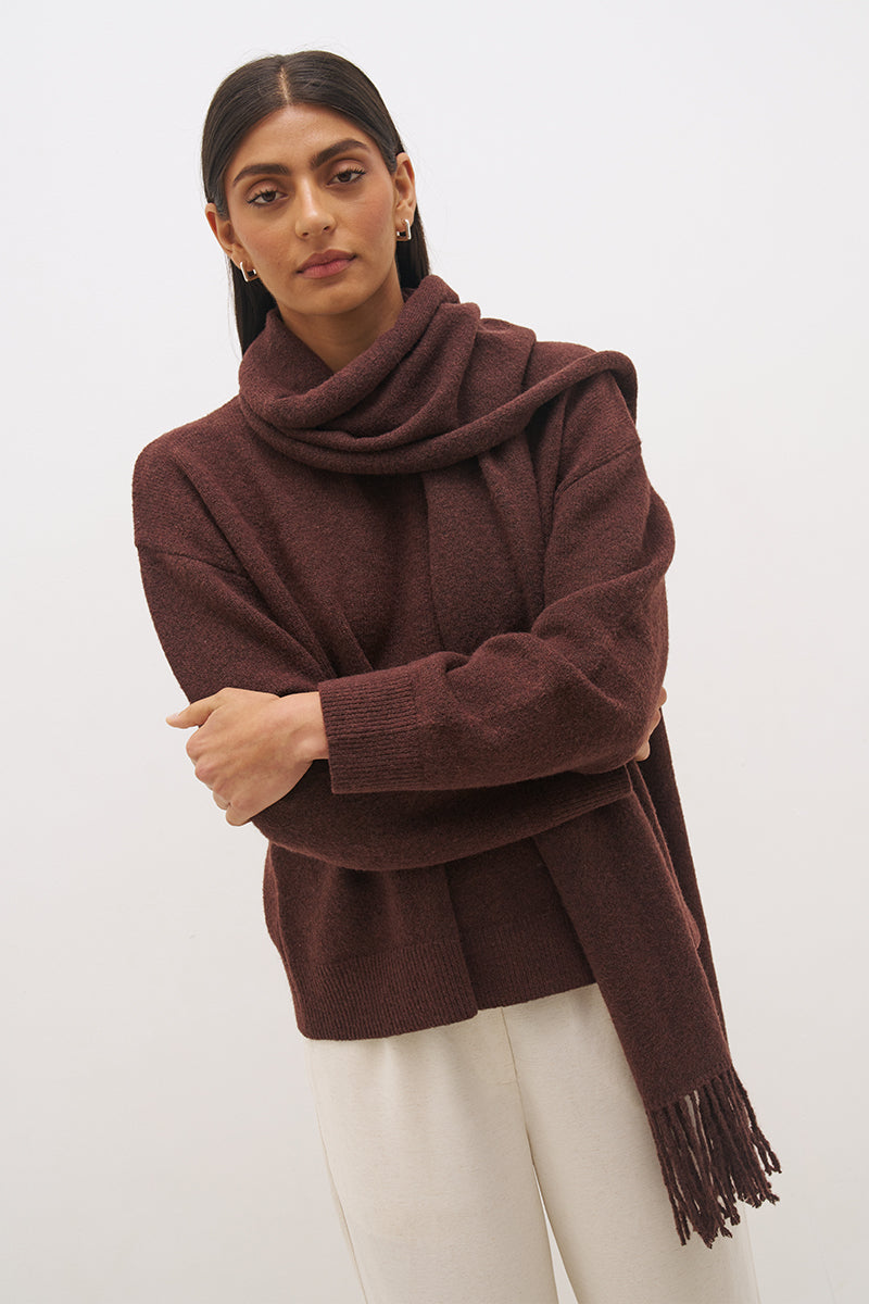 Woman wearing oversized scarf knit jumper with removable tassel scarf, crew neckline, ribbed trims, and relaxed silhouette