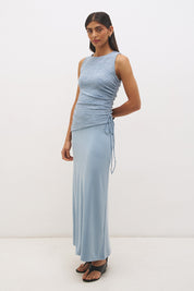 Woman wearing a sleeveless maxi dress with a textured lace bodice overlay, sunray ruching, boat neckline, and a contrast smooth A-line modal skirt in a fit-and-flare silhouette.