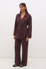 Woman wearing a satin-backed linen blend longline tunic with V neckline, curved hem, relaxed fit, and removable waist tie