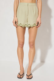 High-waisted tailored shorts with scalloped embroidery, front slant pockets, elasticated back waist, and front zipper closure