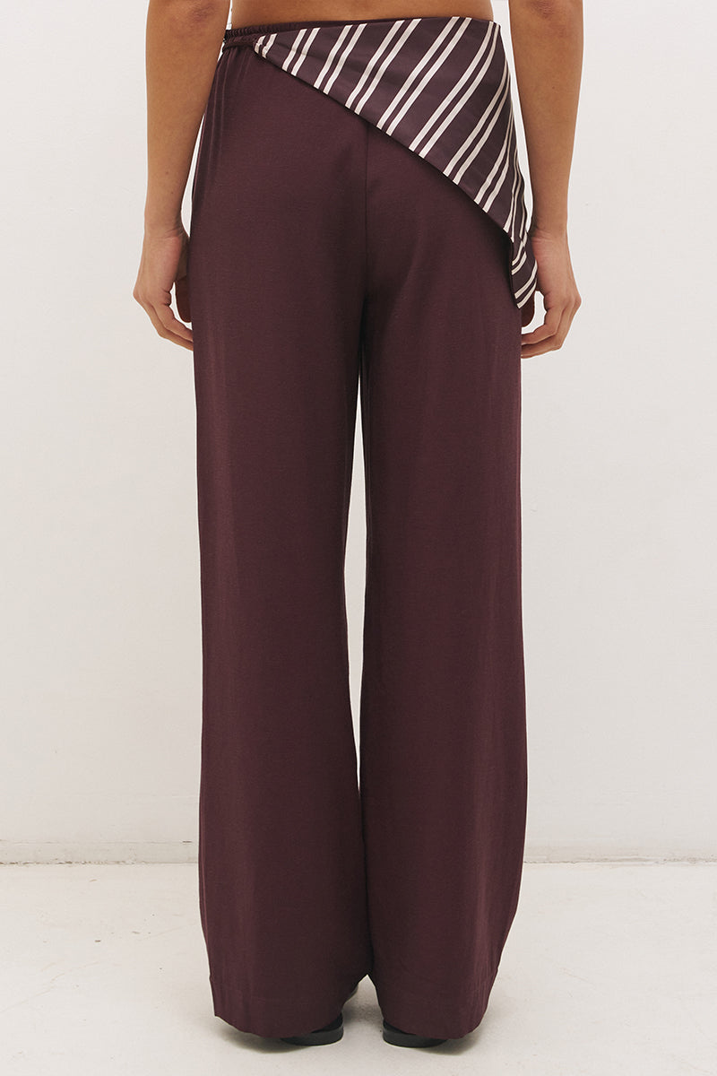 Woman wearing satin-backed linen blend wide leg pants with high-rise fit, scarf waist tie, elasticated back waistband, and relaxed tailored silhouette