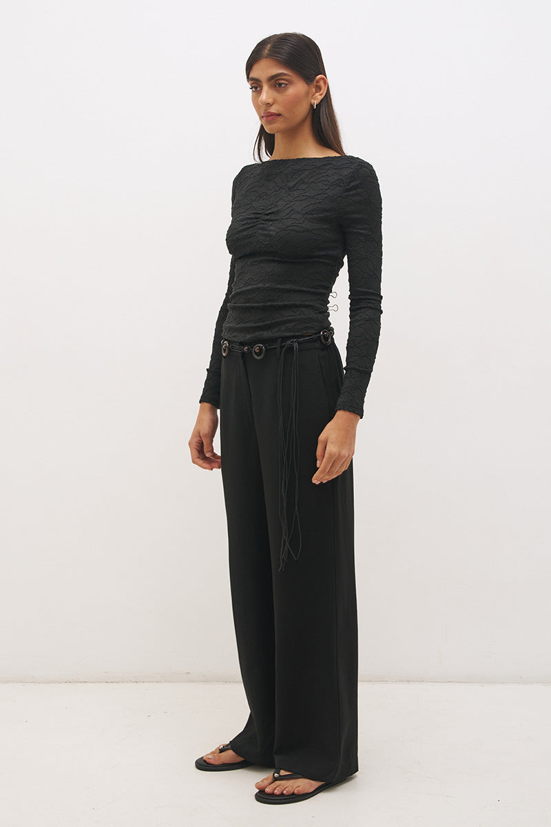 Woman wearing a textured lace long sleeve top with a boat neckline, semi-sheer sleeves, and centre front chest ruching in a skimming fit.