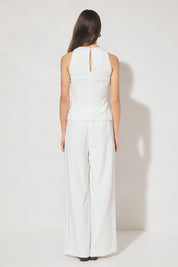 Sleeveless textured woven top with crew neckline, ladder trim detail, twisted waist sash, and side seam splits