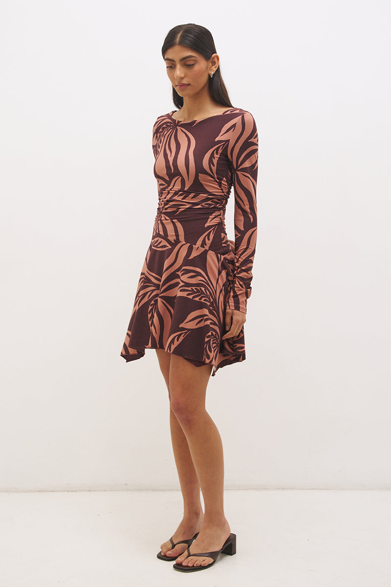 Printed handkerchief hem mini dress with boat neckline, ruched long sleeves, gathered bodice, and hi-lo draped skirt in stretch modal jersey
