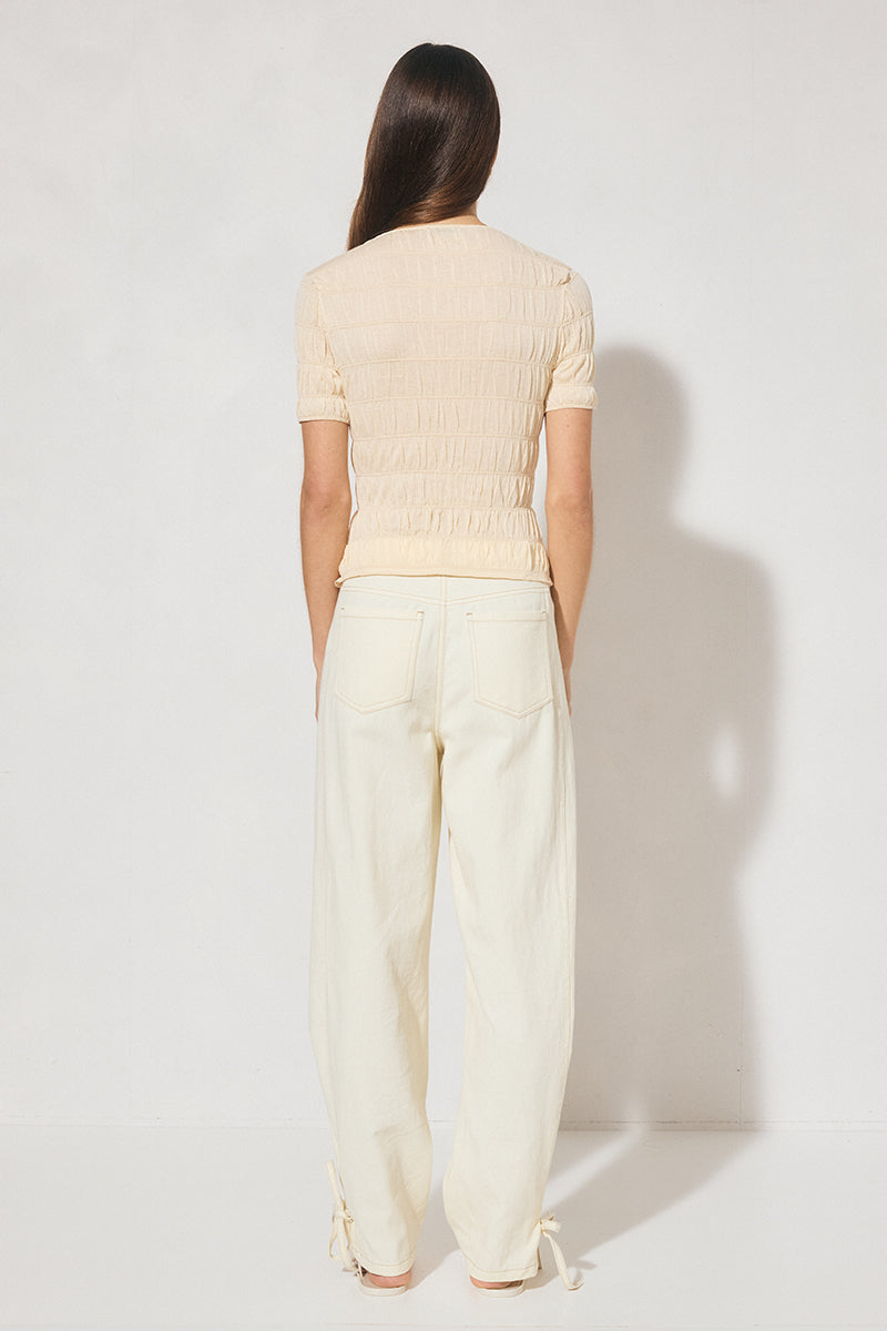 Skimming fit knitted tee shirt with round neckline, short sleeves, horizontal shirring detail, and narrow ribbed trims