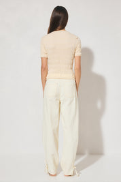 Skimming fit knitted tee shirt with round neckline, short sleeves, horizontal shirring detail, and narrow ribbed trims