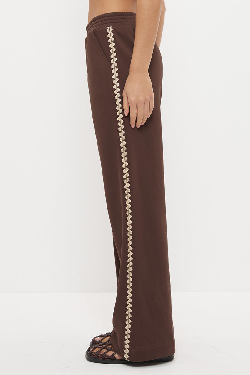 Woman wearing embroidered fleeced-back jersey sweatpants in a regular straight leg fit with contrast side seam embroidery and a topstitched elasticated waistband.