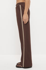 Woman wearing embroidered fleeced-back jersey sweatpants in a regular straight leg fit with contrast side seam embroidery and a topstitched elasticated waistband.