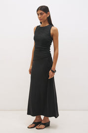 Woman wearing a sleeveless maxi dress with a textured lace bodice overlay, sunray ruching, boat neckline, and a contrast smooth A-line modal skirt in a fit-and-flare silhouette.