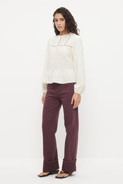 Long sleeve seersucker blouse with scalloped round neckline, balloon sleeves and lace-trimmed peplum hem
