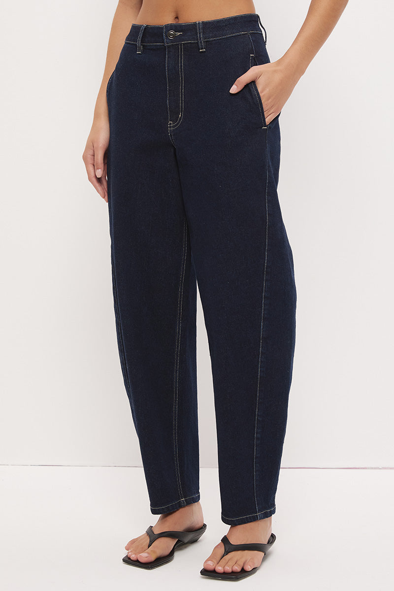 High-rise stretch denim barrel leg jeans with curved silhouette, contrast topstitching, and panelled construction
