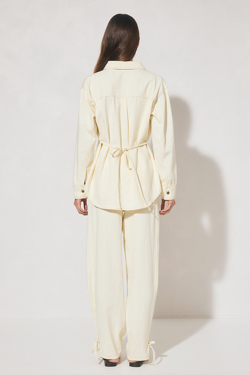 Long-sleeved oversized denim shirt with dropped shoulders, collar & stand, back box-pleat, back waist tie, chest patch pockets, side hem splits, and contrast topstitching