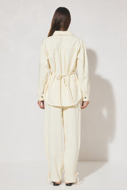 Long-sleeved oversized denim shirt with dropped shoulders, collar & stand, back box-pleat, back waist tie, chest patch pockets, side hem splits, and contrast topstitching