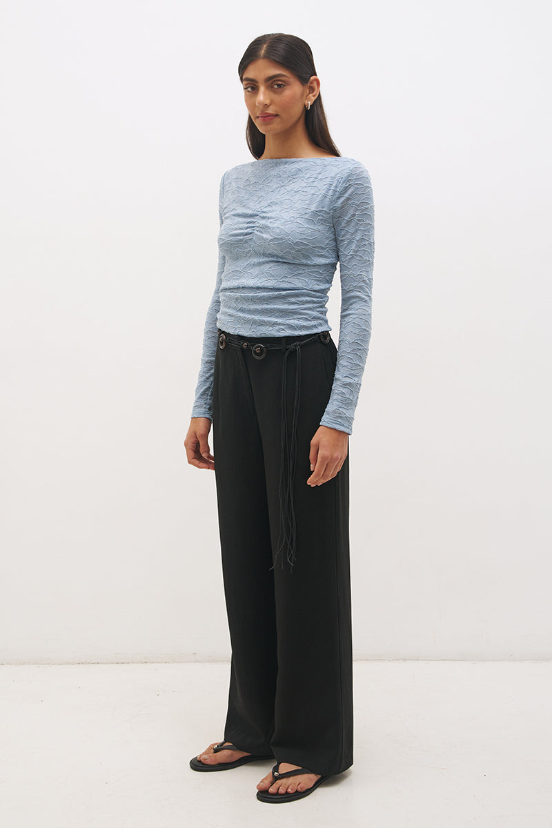 Woman wearing a textured lace long sleeve top with a boat neckline, semi-sheer sleeves, and centre front chest ruching in a skimming fit.