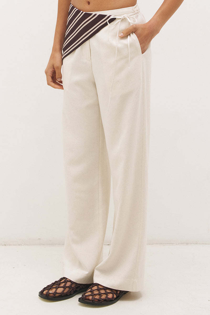 Woman wearing satin-backed linen blend wide leg pants with high-rise fit, scarf waist tie, elasticated back waistband, and relaxed tailored silhouette
