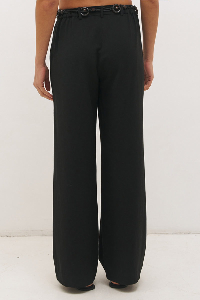 Woman wearing high-rise wide leg pants in a satin-backed linen blend with a tie-up belt featuring bead and ring detail.