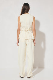 Sleeveless denim longline vest top with V neckline, pintucked waist, back tie, curved front hem, banded edges, and contrast topstitching