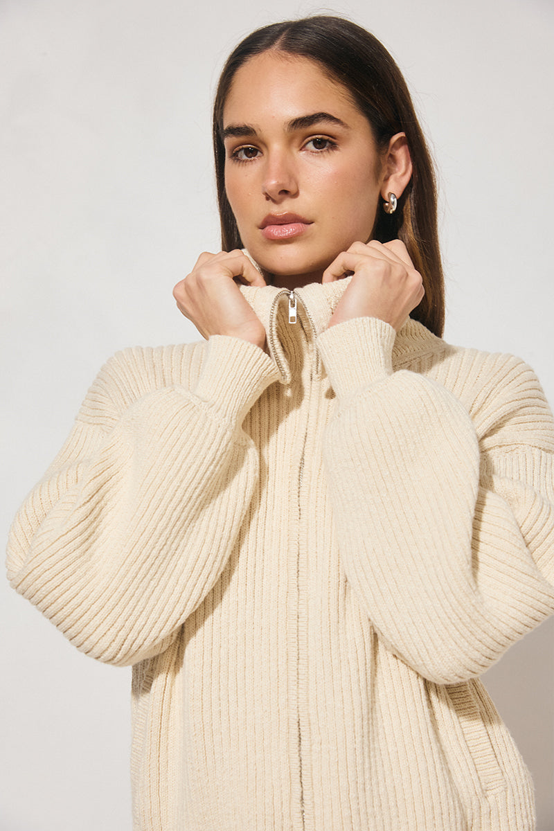 Chunky rib knit bomber jacket with wide dropped shoulders, balloon sleeves, ribbed collar and cuffs, bubble hem with internal elastic, welt pockets, and 2-way metal zipper